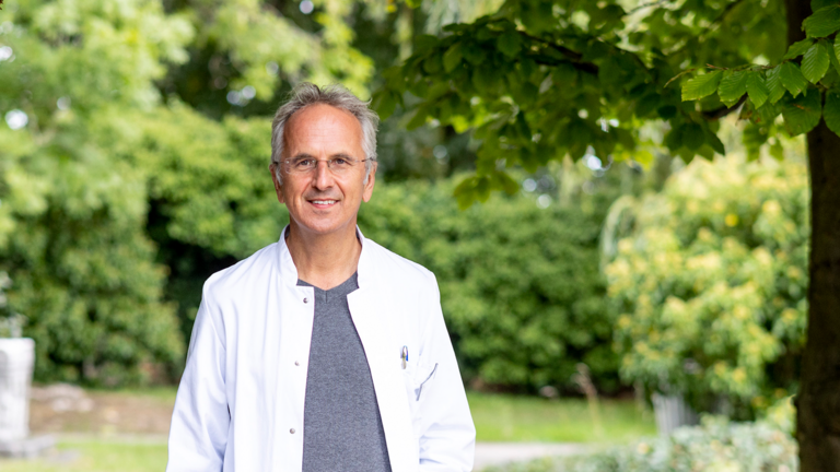  Foto von Prof. Dr. Andreas Michalsen in Krankenhauspark mit See, Chefarzt der Abteilung Naturheilkunde im Immanuel Krankenhaus Berlin
