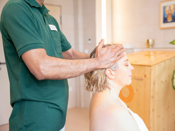 Therapeut massiert Kopf von Patientin mit Öl im Immanuel Ayurveda Zentrum