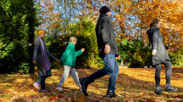 Patienten der Naturheilkunde des Immanuel Krankenhaus Berlin spazieren durch den herbstlichen Immanuel Park