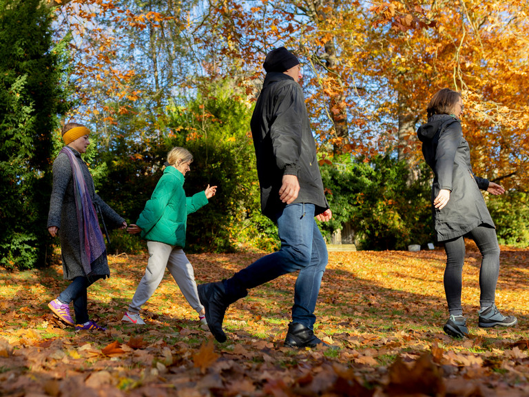 Patienten der Naturheilkunde des Immanuel Krankenhaus Berlin spazieren durch den herbstlichen Immanuel Park