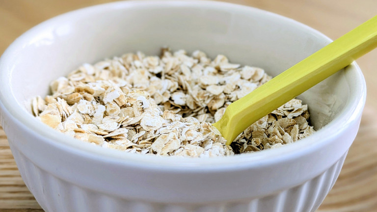 Haferflocken in Schüssel mit Löffel