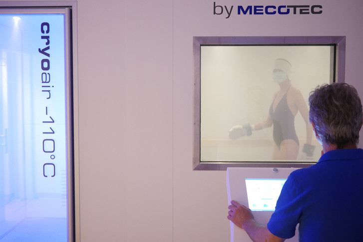 Patientin in Bewegung in der Kältekammer unter Aufsicht einer Fachkraft