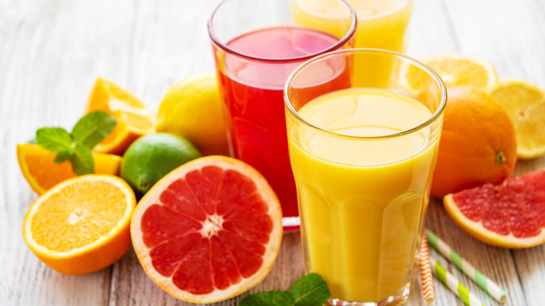 Zitrusfrüchte und Gläser gefüllt mit Saft
