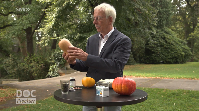 Dr. med. Rainer Stange an einem Tisch mit verschiedenen Kürbissorten