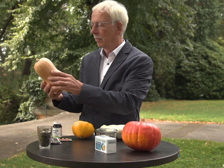 Dr. med. Rainer Stange an einem Tisch mit verschiedenen Kürbissorten