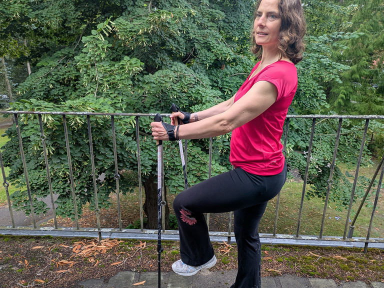 Therapeutin bei einer Nordic Walking Übung mit Stöckern uaf einer Terrasse Therapeutin bei einer Nordic Walking Übung mit Stöckern uaf einer Terrasse