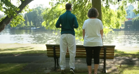 Patientin führt Übungen mit Physiotherapeut in Park aus