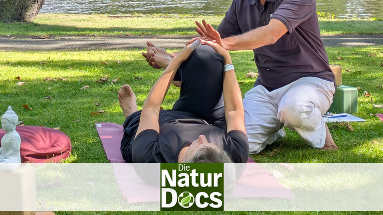 Yogatherapeut leitet Patientin bei Asana an