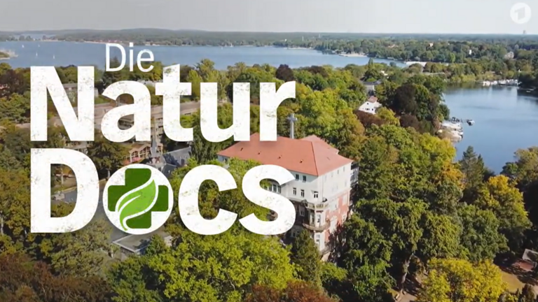 Natur-Docs-Logo im Hintergrund Blick auf Wannsee und Krankenhaus